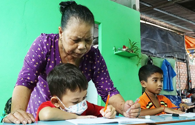Cô Trần Thị Mươn dạy trẻ Khmer viết chữ tại lớp học tình thương của mình.