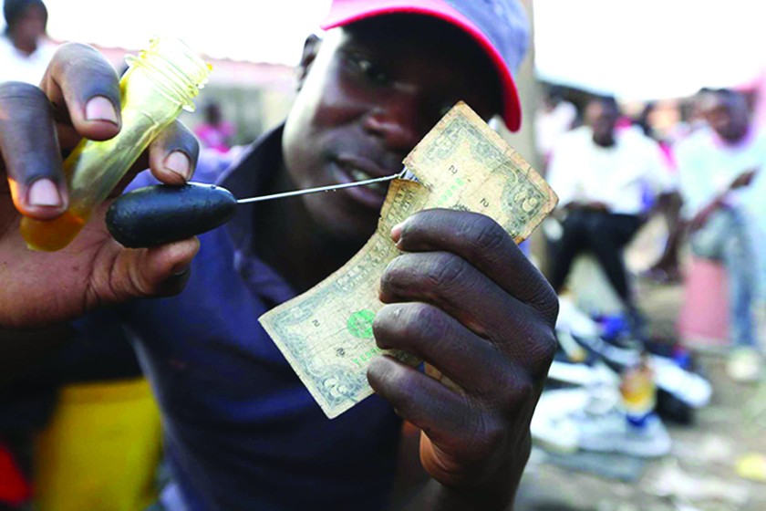Nghề “vá tiền” rách đang trở thành kế sinh nhai cho nhiều người ở Zimbabwe.