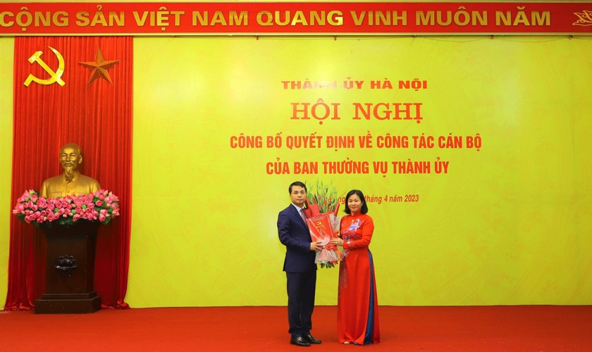 Bà Nguyễn Thị Tuyến - Ủy viên Trung ương Đảng, Phó Bí thư Thường trực Thành ủy Hà Nội trao quyết định và tặng hoa chúc mừng ông Lê Minh Đức - tân Bí thư huyện Thạch Thất.