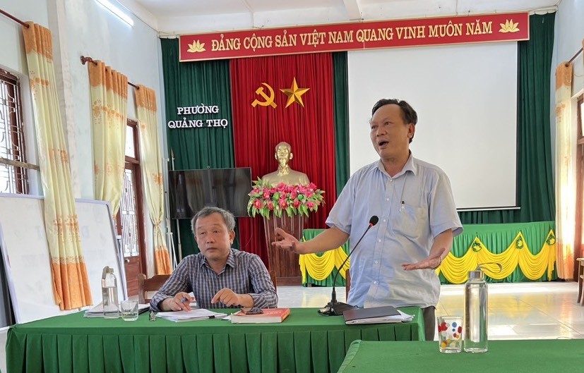 Chủ tịch UBND phường Quảng Thọ (đứng) cùng ông Đinh Nguyên Lượng giải thích thông tin với người dân về dự án. (Hình chụp ngày 5/5)