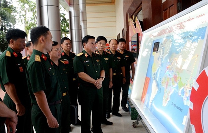 Thiếu tướng Đinh Ngọc Tường và các đại biểu tham quan khu trưng bày sáng kiến, mô hình học cụ áp dụng trong giảng bài chính trị. 