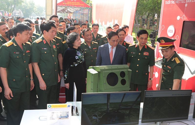 Thủ tướng Phạm Minh Chính và các đại biểu tham quan khu trưng bày sản phẩm tuổi trẻ sáng tạo trong Quân đội.