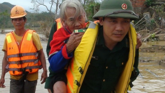 Chiến sĩ Bộ đội Biên phòng cõng một bà cụ ở huyện Quảng Trạch từ nơi trú ẩn về nhà sau khi lũ rút