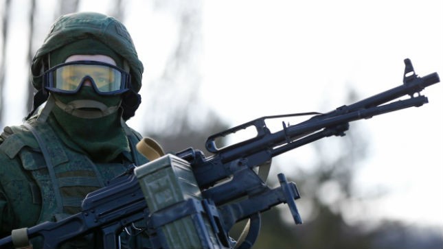 Một người được cho là binh lính Nga đứng gác bên ngoài một căn cứ quân sự của Ukraine