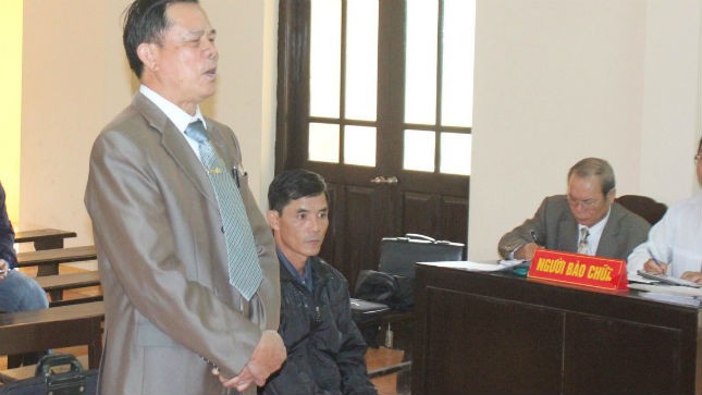 Ông Ngô Thanh Kỳ, Giám đốc Cty Cờ Đỏ (đứng) và ông Vũ Đình Đảng (ngồi) tại phiên tòa xét xử ngày 06/5/2014