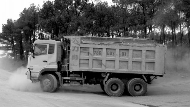 Một xe “khủng” đã được cơi nới thùng, chở đầy đất từ hướng mỏ đất xã Vĩnh Ninh về QL9B làm bụi đường tung lên mù mịt