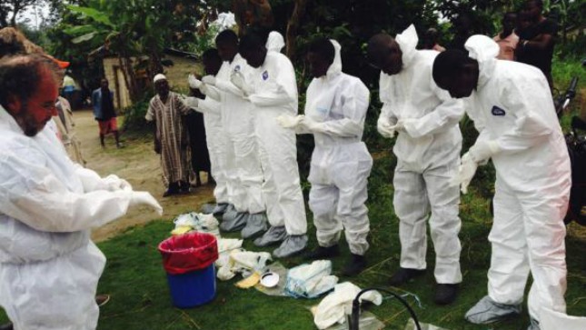 Các tình nguyện viên chuẩn bị để di chuyển thi thể các nạn nhân tử vong do Ebola. Ảnh: Reuters
