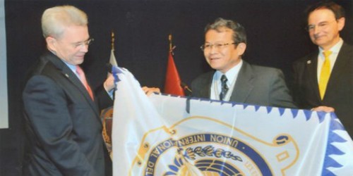 Ông Phan Văn Cheo (giữa), Trưởng phái đoàn Công chứng Việt Nam nhận cờ của Liên minh Công chứng quốc tế tại Lễ kết nạp Việt Nam làm thành viên thứ 84 của Liên minh Công chứng quốc tế ngày 9/10/2013.