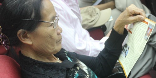 Một người dân Hà Nội đang tìm hiểu các quy định về Thừa phát lại qua các tài liệu được phát tại Hội nghị