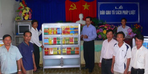 Ông Nguyễn Thanh Reo (thứ tư từ trái sang) trong lần đi trao tặng tủ sách pháp luật cho chính quyền cơ sở