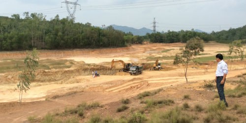 Máy xúc và xe tải đang khai thác đất ở hồ Vệ Nông