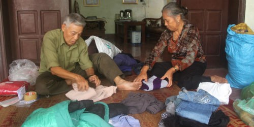 Cựu chiến binh Nguyễn Đức Thành đang đóng gói quần áo, chăn màn... để chuyển đi ủng hộ người nghèo