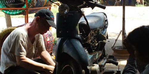 Anh Văn Viết Điền đang sửa xe máy cho khách