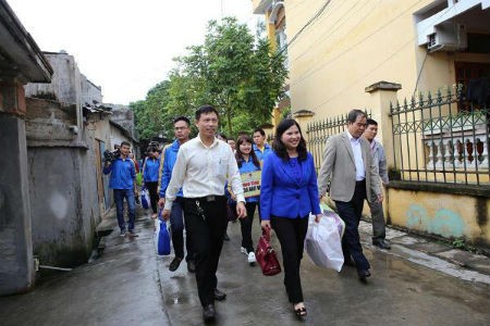 Ban lãnh đạo công ty Dược Phẩm Tâm Bình và TBT Tạp chí Người Làm Báo (hàng đầu) trên đường vào nhà tặng quà cho chị Trần Thị Mến
