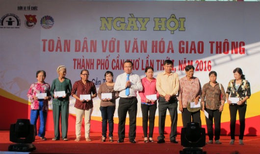 Ông Khuất Việt Hùng, Phó Chủ tịch chuyên trách Ủy ban ATGT Quốc gia (thứ 5 từ trái sang) trao quà hỗ trợ cho các gia đình có người thân bị tai nạn giao thông