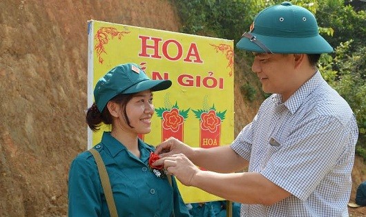Đồng chí Lục Đại Lượng - Phó Giám đốc Đài PT-TH tỉnh Bắc Kạn - gắn “hoa bắn giỏi” cho một nữ dân quân