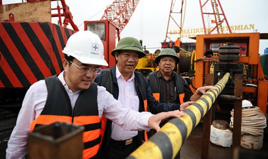Chủ tịch EVN Dương Quang Thành (bìa trái) và lãnh đạo tỉnh Quảng Nam kiểm tra việc rải cáp biển cấp điện cho Cù Lao Chàm