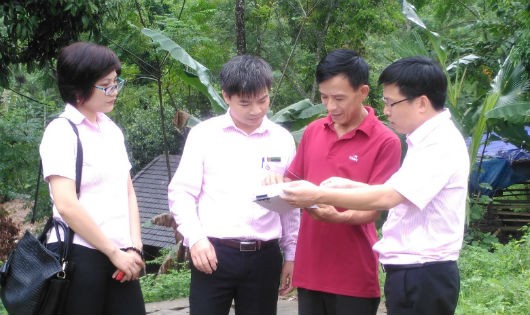 Ông Lục Văn Vui (thứ 3 từ trái sang) trao đổi nghiệp vụ với cán bộ NHCSXH trước giờ đi thăm hộ vay