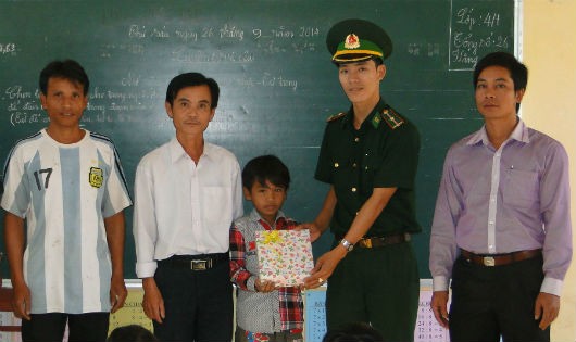 Thiếu úy Võ Văn Vinh (thứ 2 bìa phải) tặng vở cho học sinh nghèo tại Trường Tiểu học A Đớt