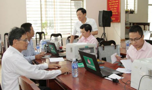 Đến Điểm giao dịch của NHCSXH tại xã Hoà Nhơn, Tổng Giám đốc Dương Quyết Thắng (người đứng) đã động viên, thăm hỏi các cán bộ Phòng giao dịch NHCSXH huyện Hoà Vang và bà con vay vốn trong xã