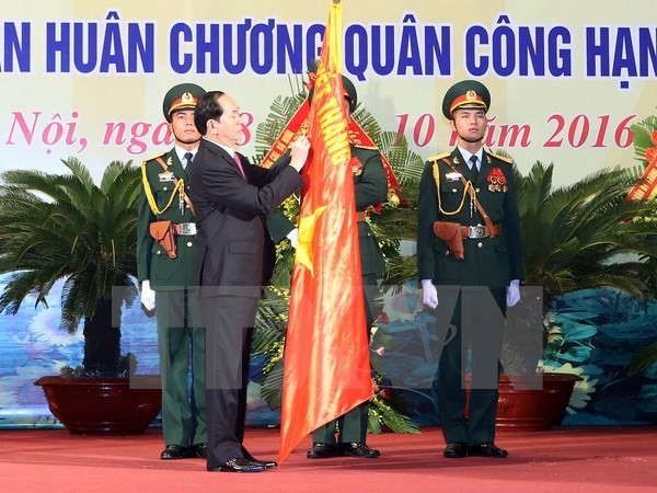 Chủ tịch nước Trần Đại Quang gắn Huân chương Quân công hạng Nhất lên lá cờ truyền thống của lực lượng vũ trang Thủ đô.