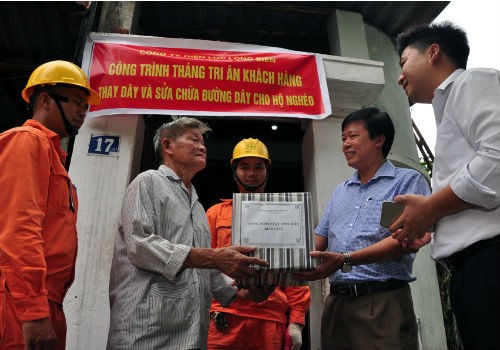 Ông Vũ Văn Tùng - Phó Giám đốc Công ty Điện lực quận Long Biên tặng quà cho hộ gia đình hoàn cảnh khó khăn trên địa bàn quận