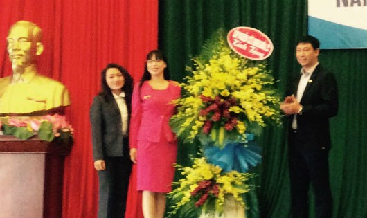 Thay mặt Ban giám hiệu,  TS. Vũ Thị Lan Anh nhận lẵng hoa chúc mừng khai giảng từ đại diện nghiên cứu sinh khóa 22