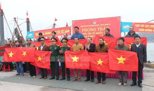 Thủ trưởng Bộ CHQS tỉnh tặng cờ Tổ quốc cho 10 hộ dân đại diện cho các ngư dân trên trên địa ban. Ảnh QĐND