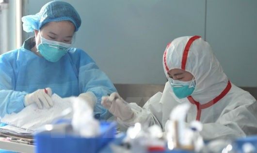 Nhân viên y tế Trung Quốc điều trị cho một bệnh nhân nhiễm virus cúm gia cầm H7N9 tại Trung tâm y tế Vũ Hán ở Hồ Bắc, miền trung Trung Quốc ngày 12/2. (Nguồn: EPA/TTXVN)