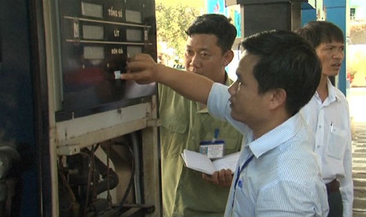 Dán tem niêm phong công tơ tổng trụ bơm xăng, dầu. Ảnh  Khánh Phong/binhthuantv.vn