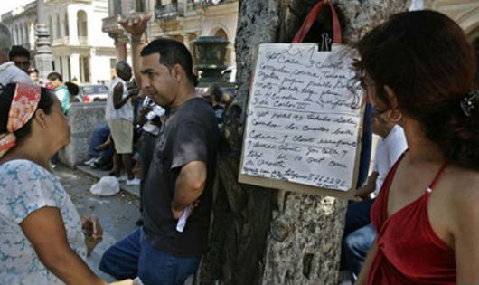 Người dân Cuba xem các thông tin bán nhà dán trên phố