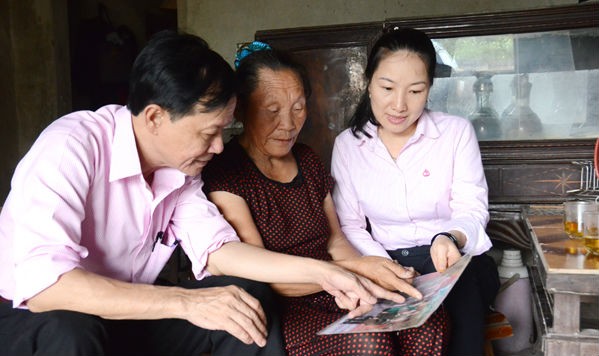Các cán bộ NHCSXH nghe cựu TNXP Trương Thị Oanh kể về những ngày mở đường cho xe ra tiền tuyến