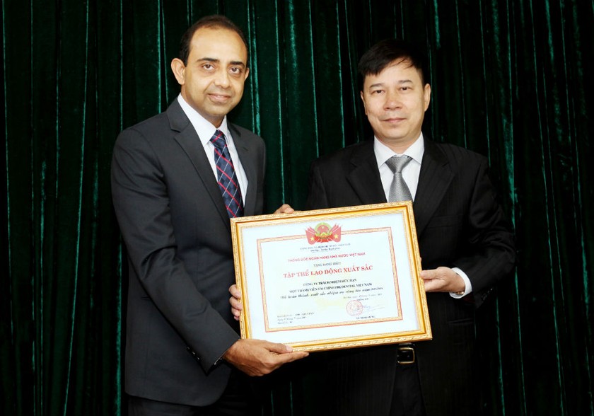 Đại diện lãnh đạo Vụ Thi đua - Khen thưởng Ngân hàng Nhà nước (phải) trao Danh hiệu Tập thể Lao động Xuất sắc cho Tổng giám đốc của Công ty Tài chính Prudential. Ảnh: Minh Đức