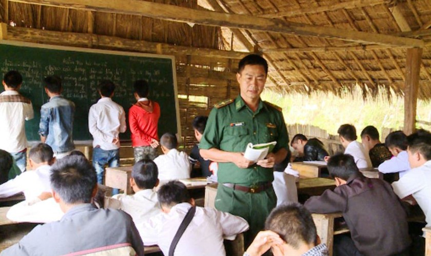 Cán bộ Đồn BP Thông Thụ dạy tiếng Việt cho người dân cụm bản Nậm Táy