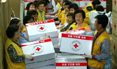 Nhân viên Chữ Thập Đỏ chuẩn bị hàng viện trợ cho Triều Tiên năm 2004. Ảnh: Guardian/VnE