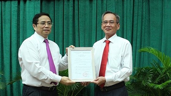 Trưởng Ban Tổ chức Trung ương Phạm Minh Chính trao quyết định cho ông Lữ Văn Hùng. - Ảnh: SGGP