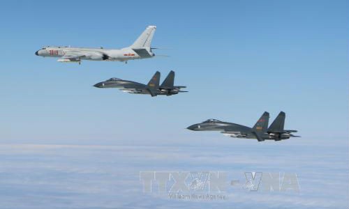 Máy bay chiến đấu Hàn Quốc (phía dưới) xuất kích sau khi phát hiện máy bay quân sự Trung Quốc (phía trên) xâm phạm không phận ngày 18/12/2017. Ảnh: YONHAP/TTXVN