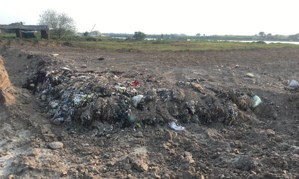 Hố chôn rác rộng vài trăm mét vuông được cho là trái phép ở ngoài bãi đê thôn Kinh Dương