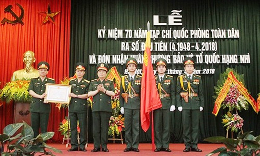 Đại tướng Ngô Xuân Lịch gắn Huân chương Bảo vệ Tổ quốc hạng Nhì lên Quân kỳ Quyết thắng và trao Bằng chứng nhận tặng Tạp chí Quốc phòng toàn dân