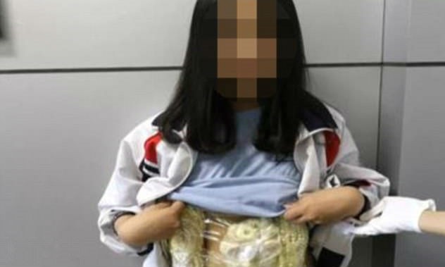 Bé gái Việt Nam bị phát hiện mang theo trang sức bằng ngà voi khi đi qua cửa khẩu Đông Hưng, Trung Quốc. Ảnh: Guangxi TV/Zing