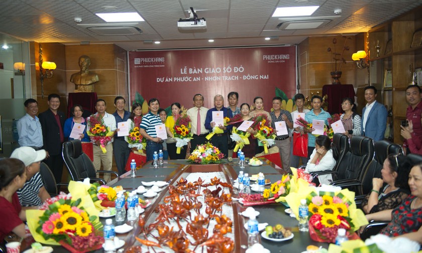 Ông Lê Hoàng Châu – Chủ tịch Hiệp hội BĐS TP.HCM trao sổ đỏ, hoa và quà cho khách hàng
