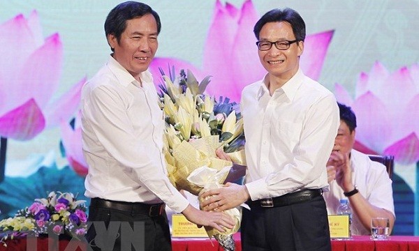 Phó Thủ tướng Vũ Đức Đam (bên phải) tặng hoa Chủ tịch Hội Nhà báo Việt Nam Thuận Hữu, chúc mừng những người làm báo trên cả nước