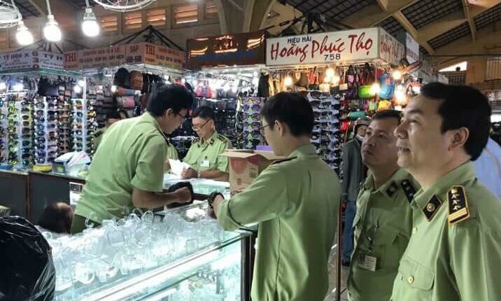 Ông Trần Hùng (bìa phải) cùng Tổ 334 kiểm tra xuất xứ hàng hoá tại chợ Bến Thành, TP HCM