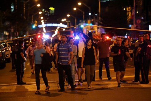 Mọi người rời khỏi khu vực đã bị cảnh sát phong tỏa gần địa điểm xảy ra vụ xả súng tại Toronto. Ảnh: Reuters/VOV