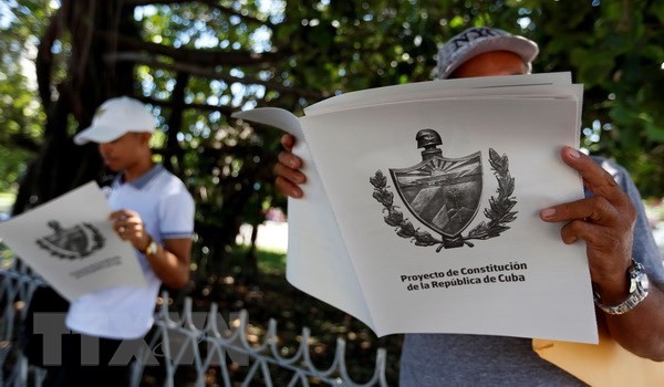 Người dân đọc chuyên san đăng tải Dự thảo Hiến pháp mới của Cuba tại La Habana. (Nguồn: EFE-EPA/TTXVN)