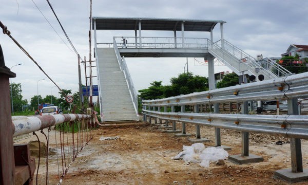 Sau khi cầu bộ hành hoàn thành, hàng rào chắn được lập, phương tiện muốn qua quốc lộ 1 phải đi vòng