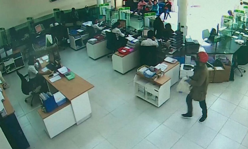 Hình ảnh tên cướp (góc phải) cầm súng khống chế mọi người trong vụ cướp ngân hàng tại Khánh Hòa