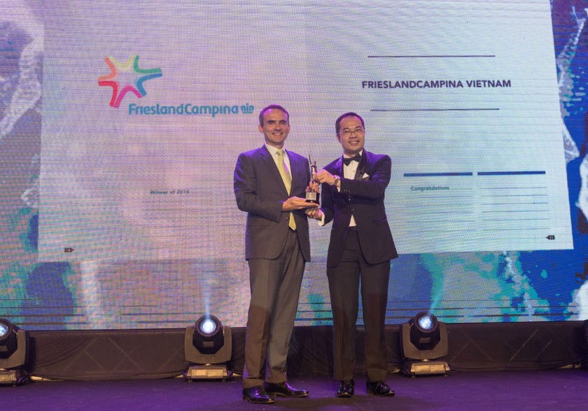 Ông Arnoud van den Berg – TGĐ Công ty FrieslandCampina Việt Nam (bên trái) nhận kỷ niệm chương tại buổi lễ công bố