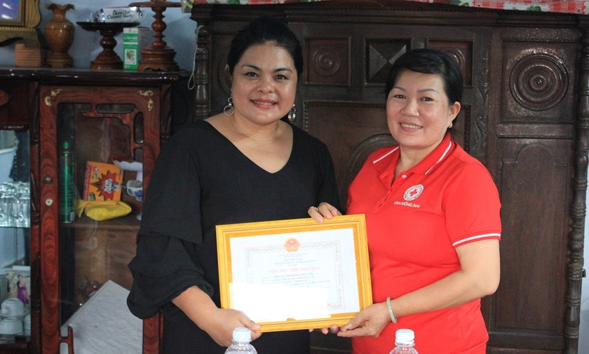 Chủ tịch Hội Chữ Thập Đỏ huyện Long Thành - bà Nguyễn Thị Ngọc Đẹp trao giấy ghi nhận tấm lòng vàng nhân đạo cho đại diện Vedan Việt Nam