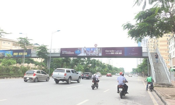 Biển chỉ dẫn giao thông trên cầu vượt bộ hành trên đường Võ Chí Công “nhường” vị trí cho biển quảng cáo